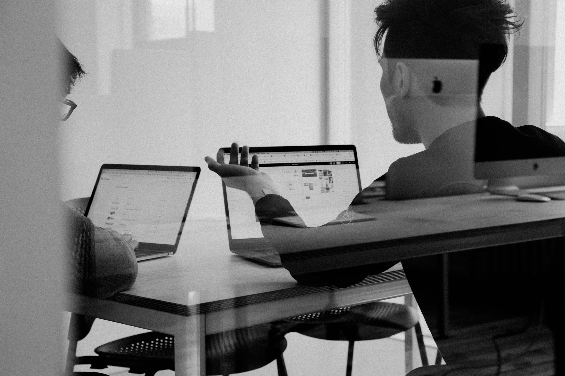 Two consultants working through analysis together at a shared desk
